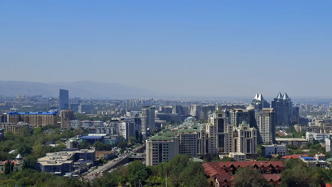 Панорама Алматы с городской застройкой и деловыми зданиями.