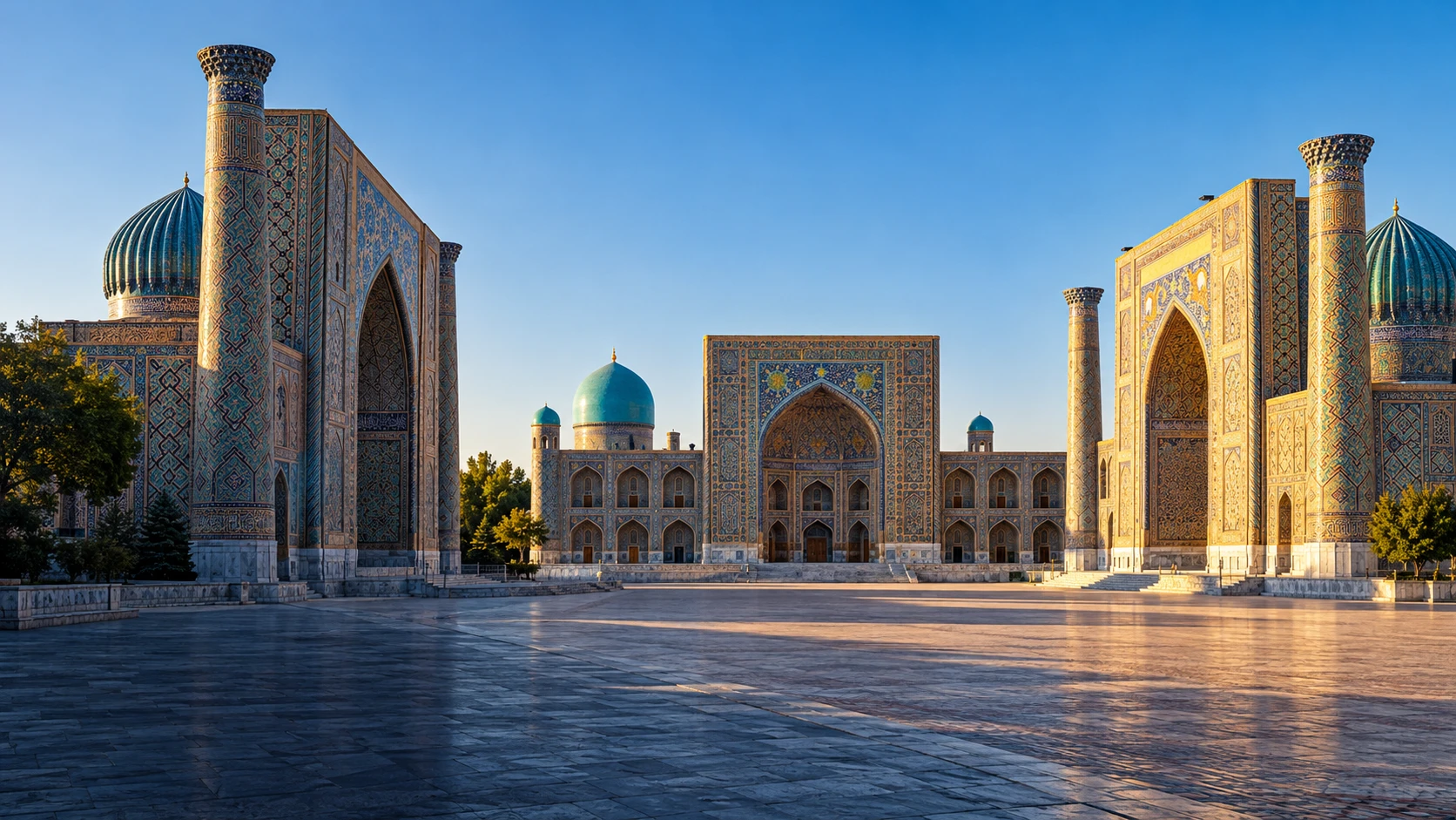The architecture of Registan Square in Samarkand, with blue-tiled madrasas and domes in morning light.